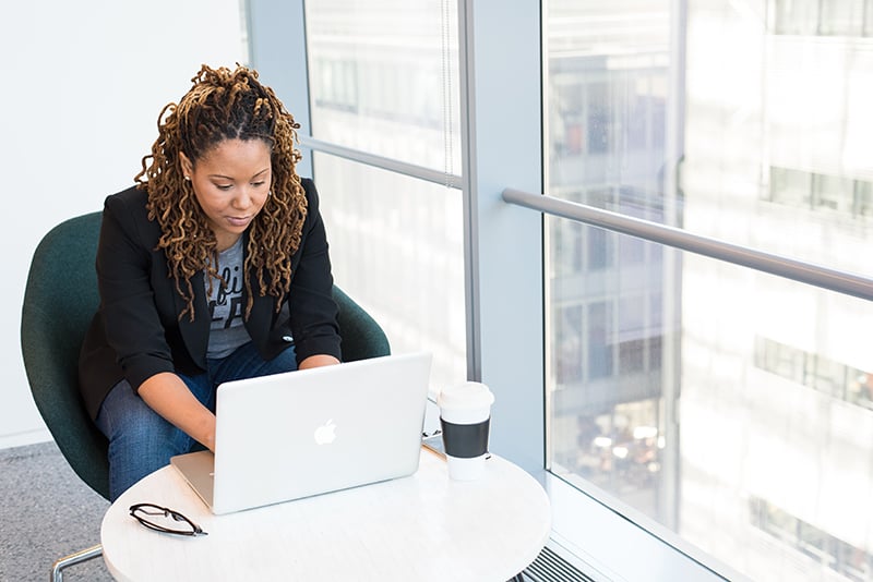 Woman on laptop conducting competitor research